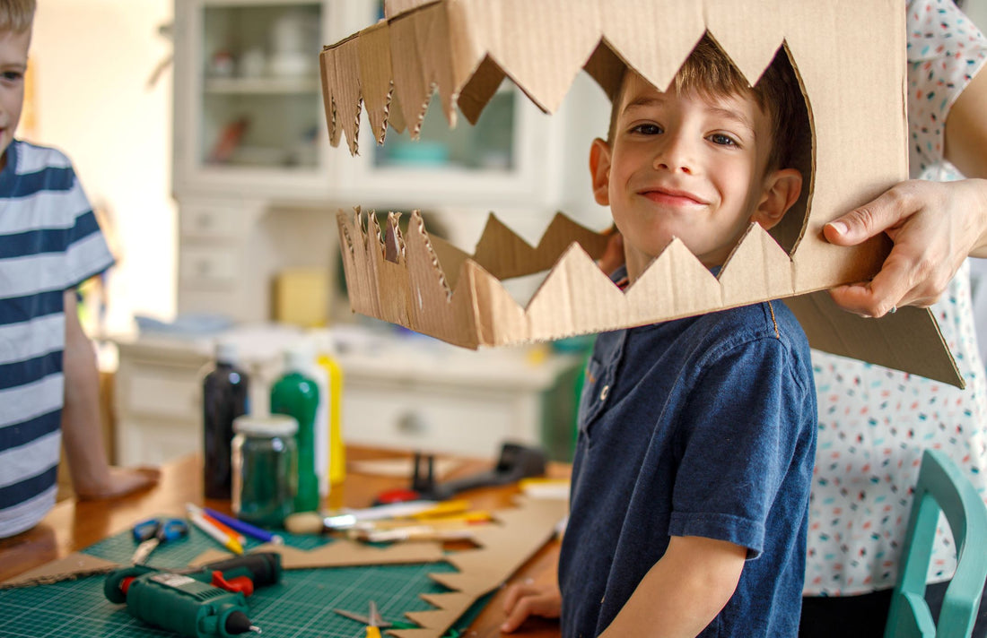 Enfant qui s'amuse à créer un déguisement avec du carton recyclé