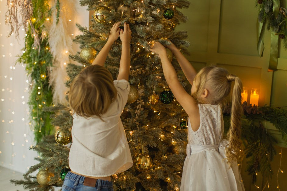 Enfants qui décorent le sapin de Noël